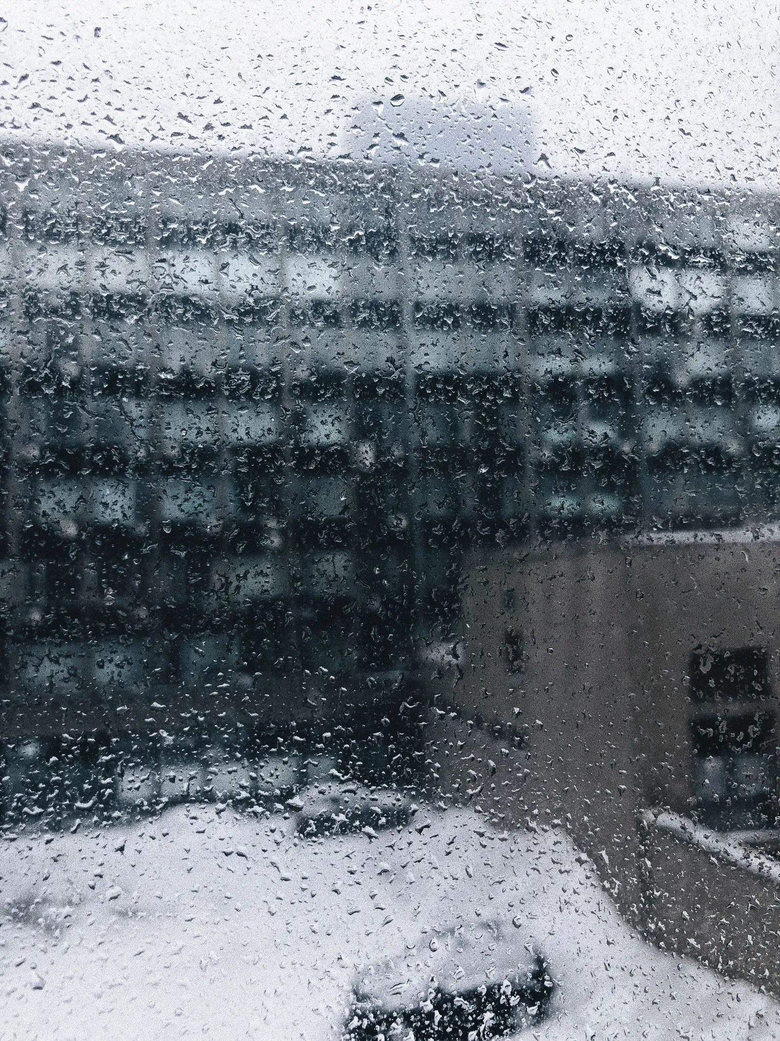 Water droplets on a window pane on a snowy day
